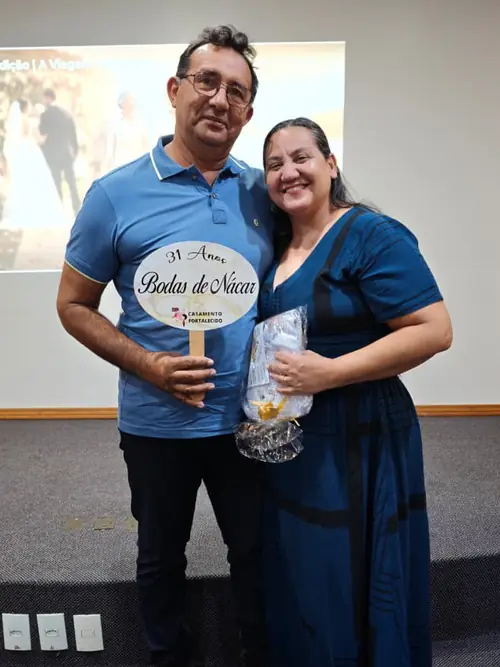 Casal da Viagem das Bodas segurando a plaquinha de 31 anos de casados, Bodas de Nácar